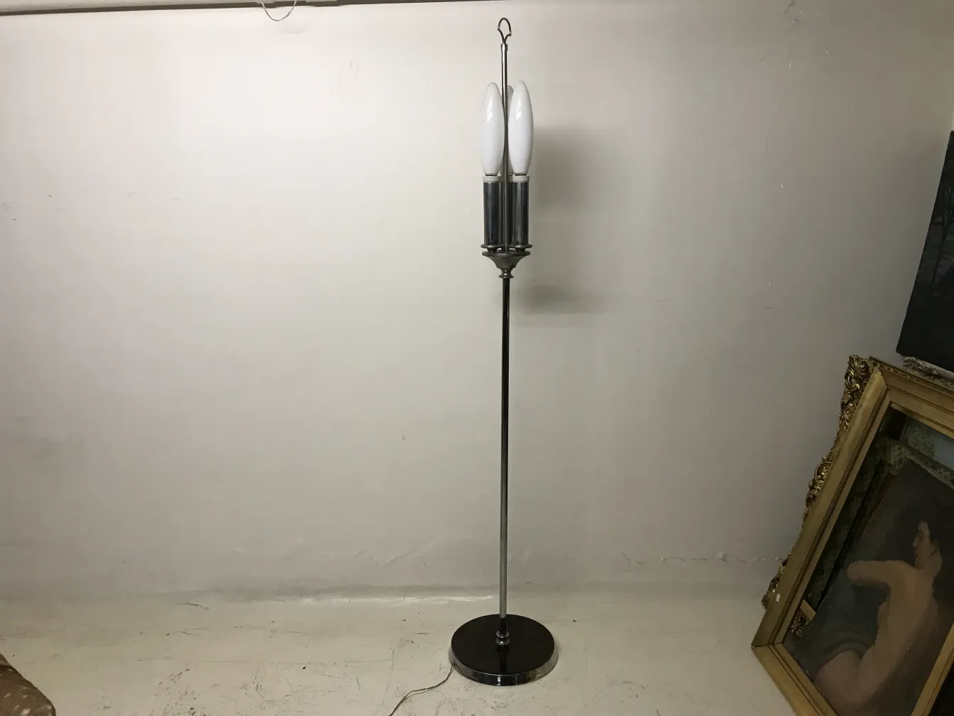 Antigua lámpara de pie en sala, con dos bombillas blancas.