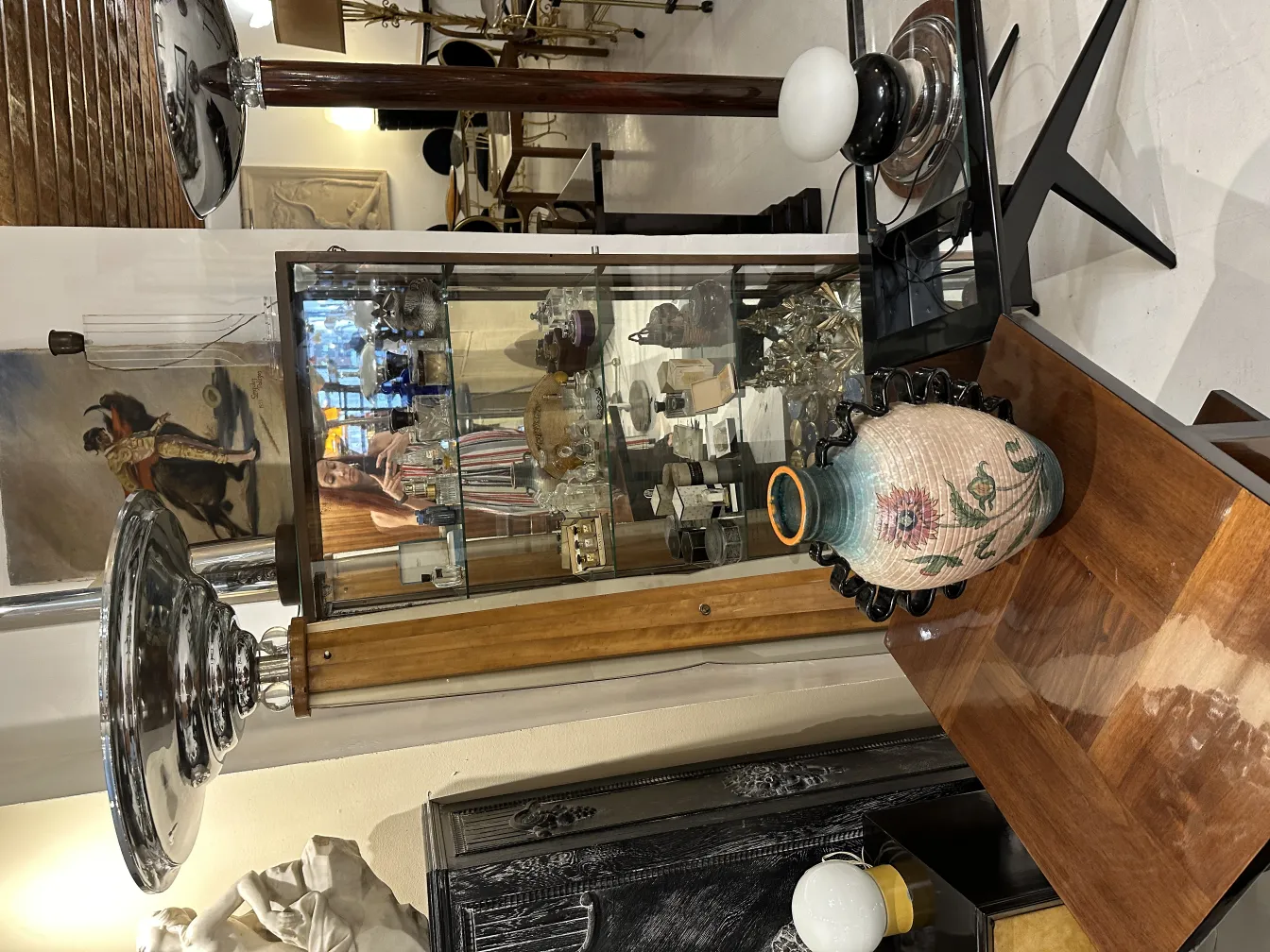 Lampada da terra antica con base in legno e paralume lucido, circondata da antiquariato.