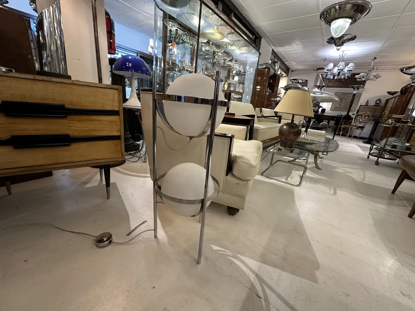 Lampada da terra antica con base elegante e paralumi rotondi in un ambiente accogliente.