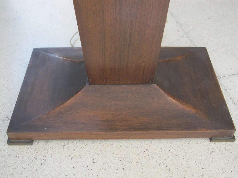 Base of an antique floor lamp with an elegant design in a neutral setting.