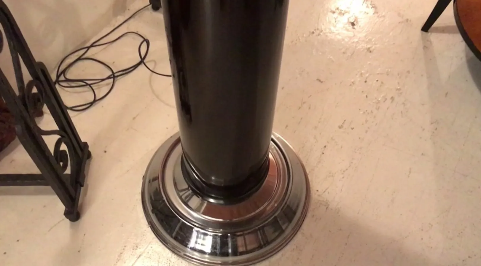 Antike Stehleuchte mit stilvoller Basis in einem gemütlichen Raum.