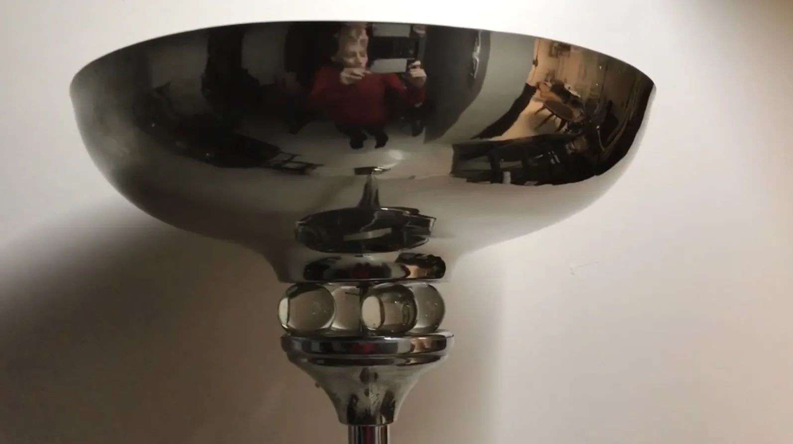 Lampe de sol ancienne avec un design élégant et une base en verre, diffusant une lumière chaleureuse.