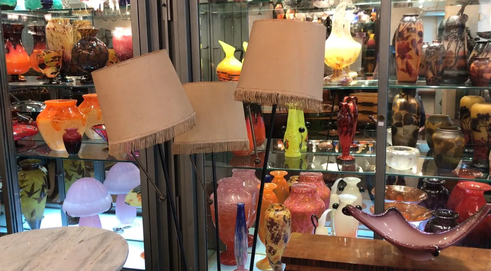 Três luminárias de pé antigas com abajures bege em um ambiente decorativo