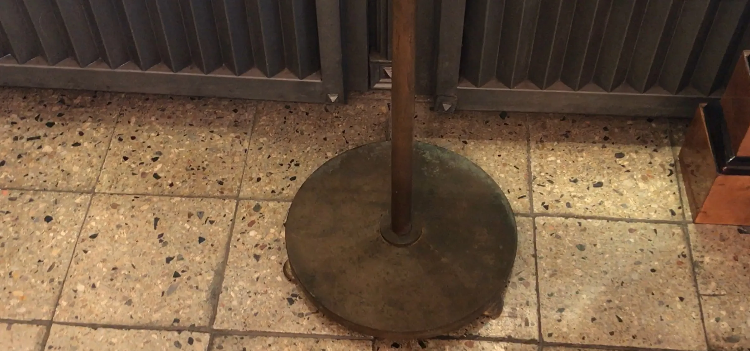 antike Stehleuchte mit runder Basis und Metallstruktur in einem gemütlichen Umfeld