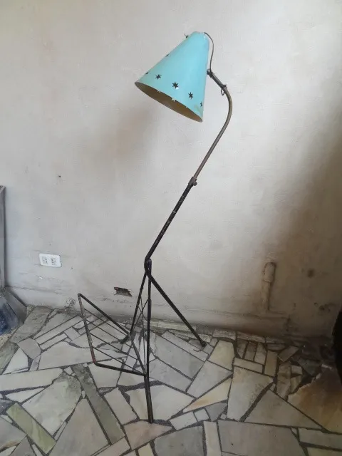 Antique floor lamp with a blue shade and black stand in a cozy setting.