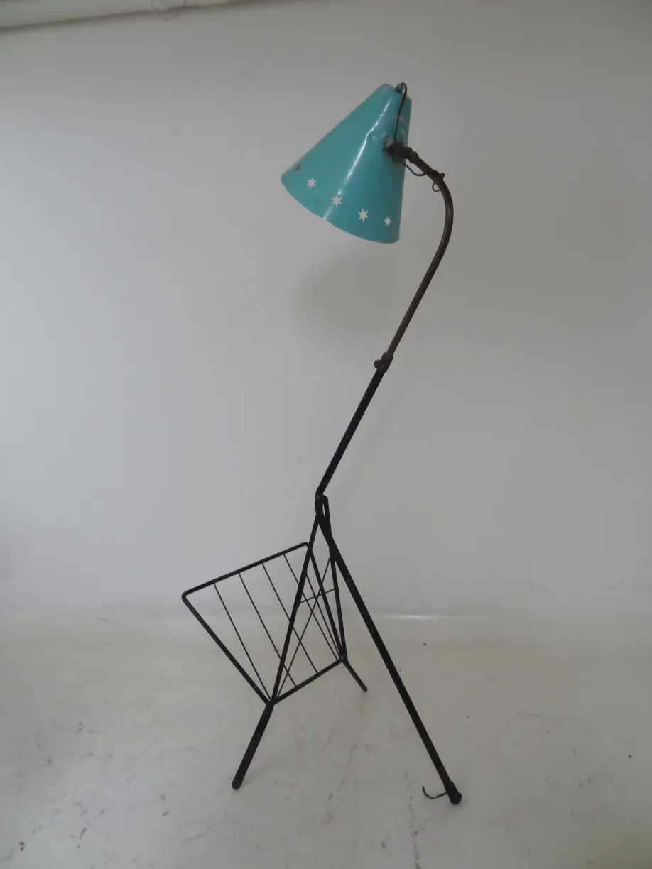 Lámpara de pie antigua con pantalla azul y diseño elegante, rodeada de un ambiente neutral.