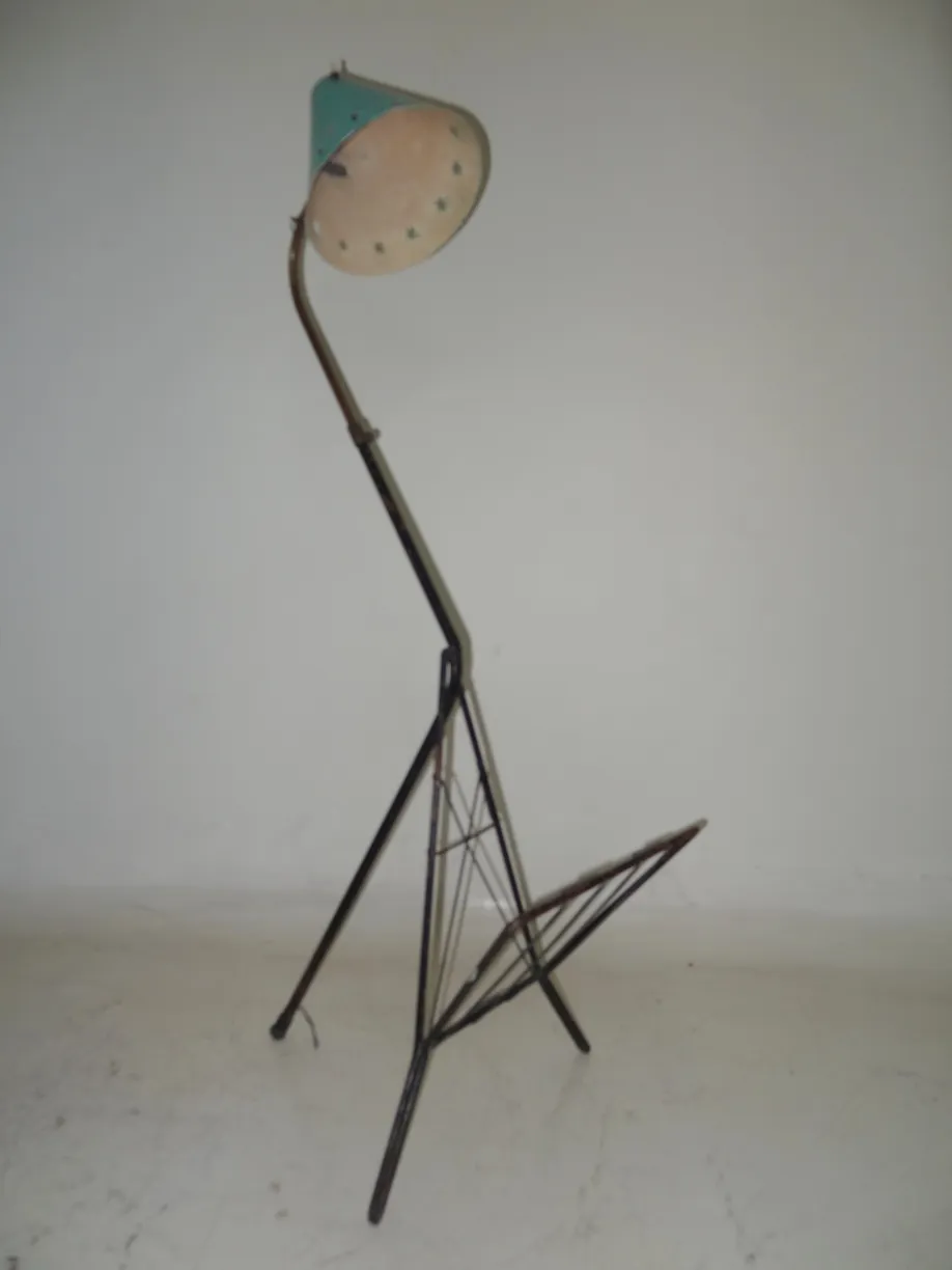 Antique floor lamp with an elegant design and green shade, in a modern setting.