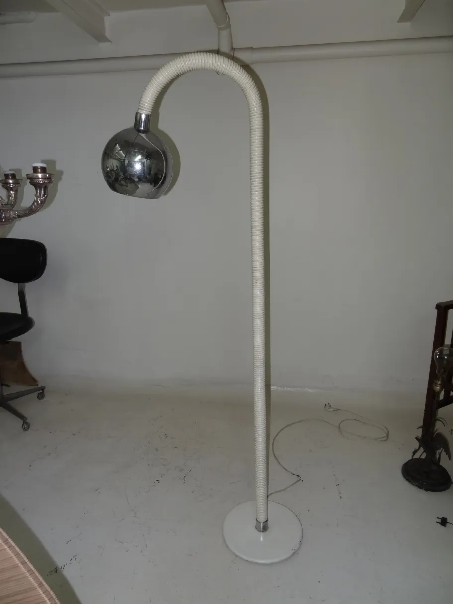 Luminária de pé antiga com design curvado em ambiente moderno, perfeita para sala.