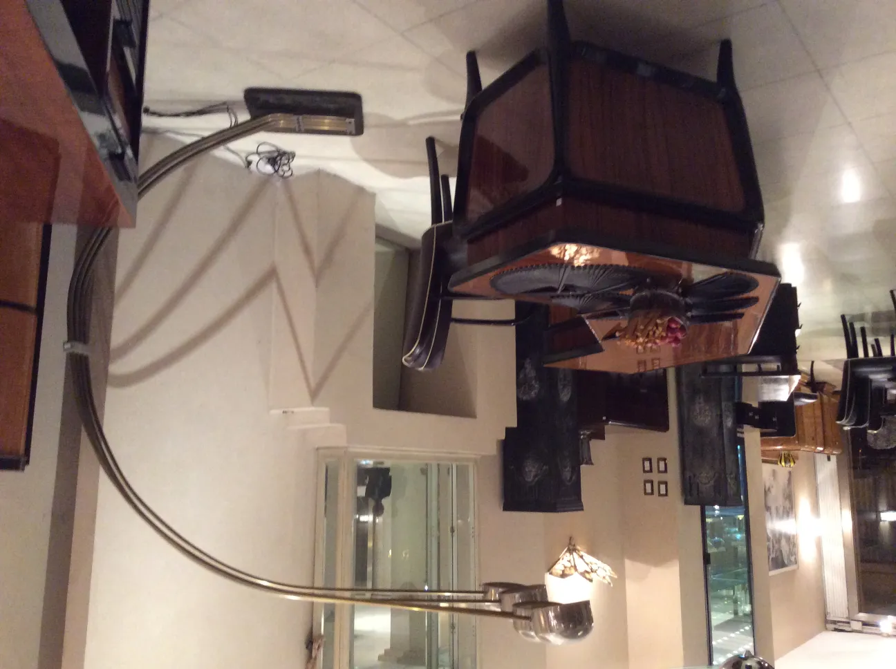 Lámpara de pie antigua con base curva y luz en forma de sombrero, ambiente elegante