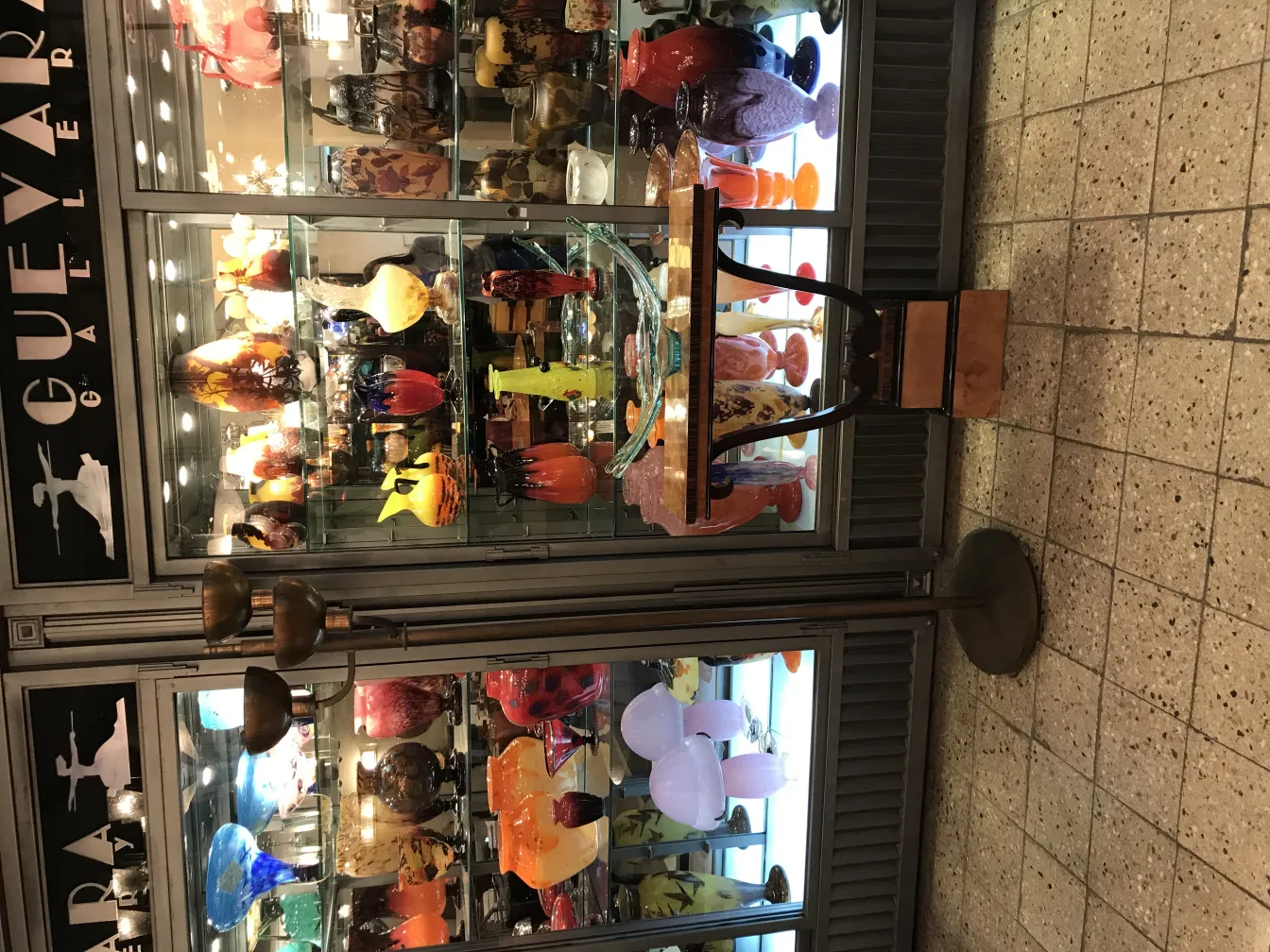 오래된플로어램프, 클래식한디자인과두개의전구가있는, 유리제품으로가득찬갤러리환경에서.