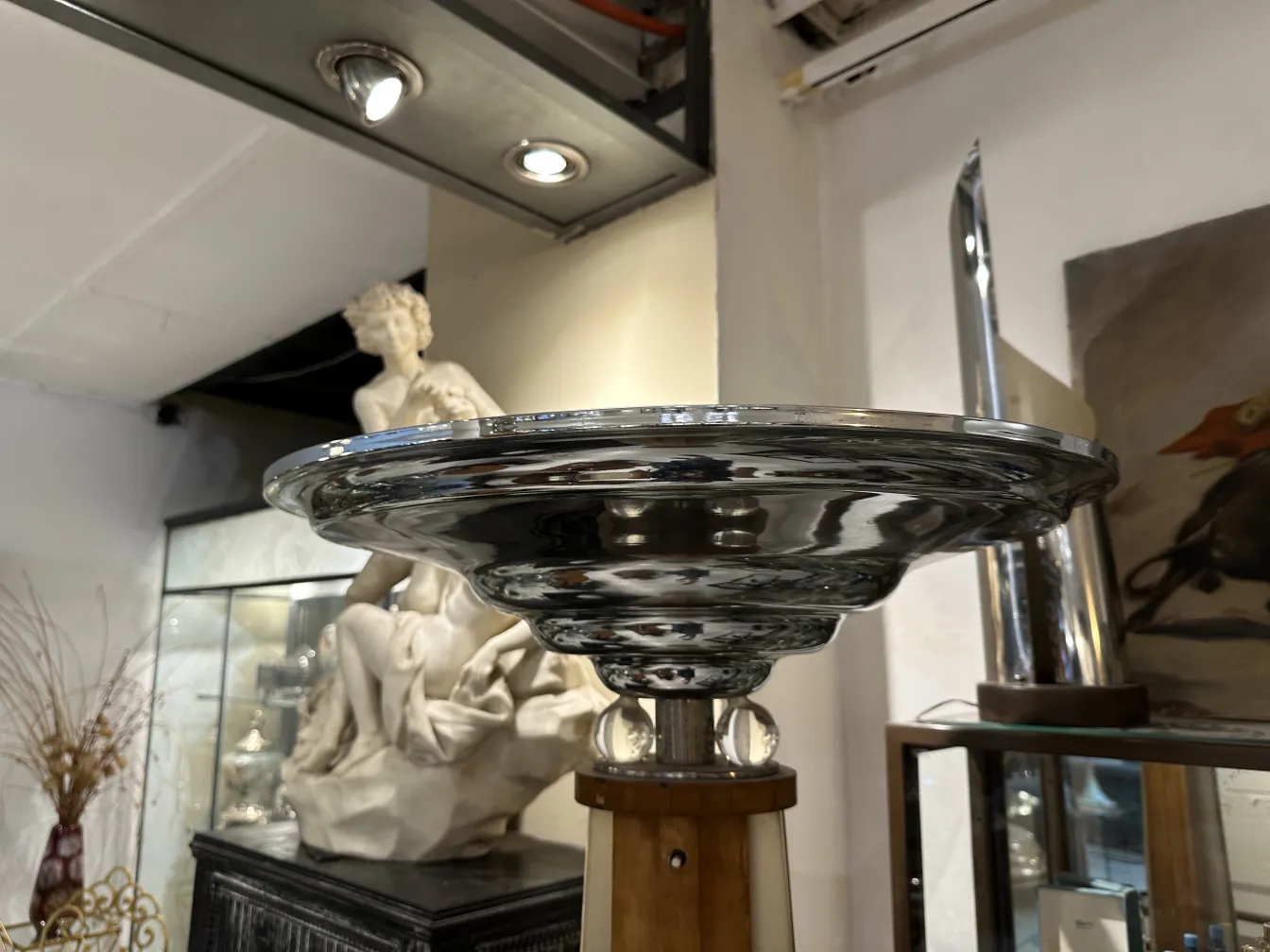 Lampada da terra antica con una base elegante e un design distintivo nell'ambiente decorativo della stanza.