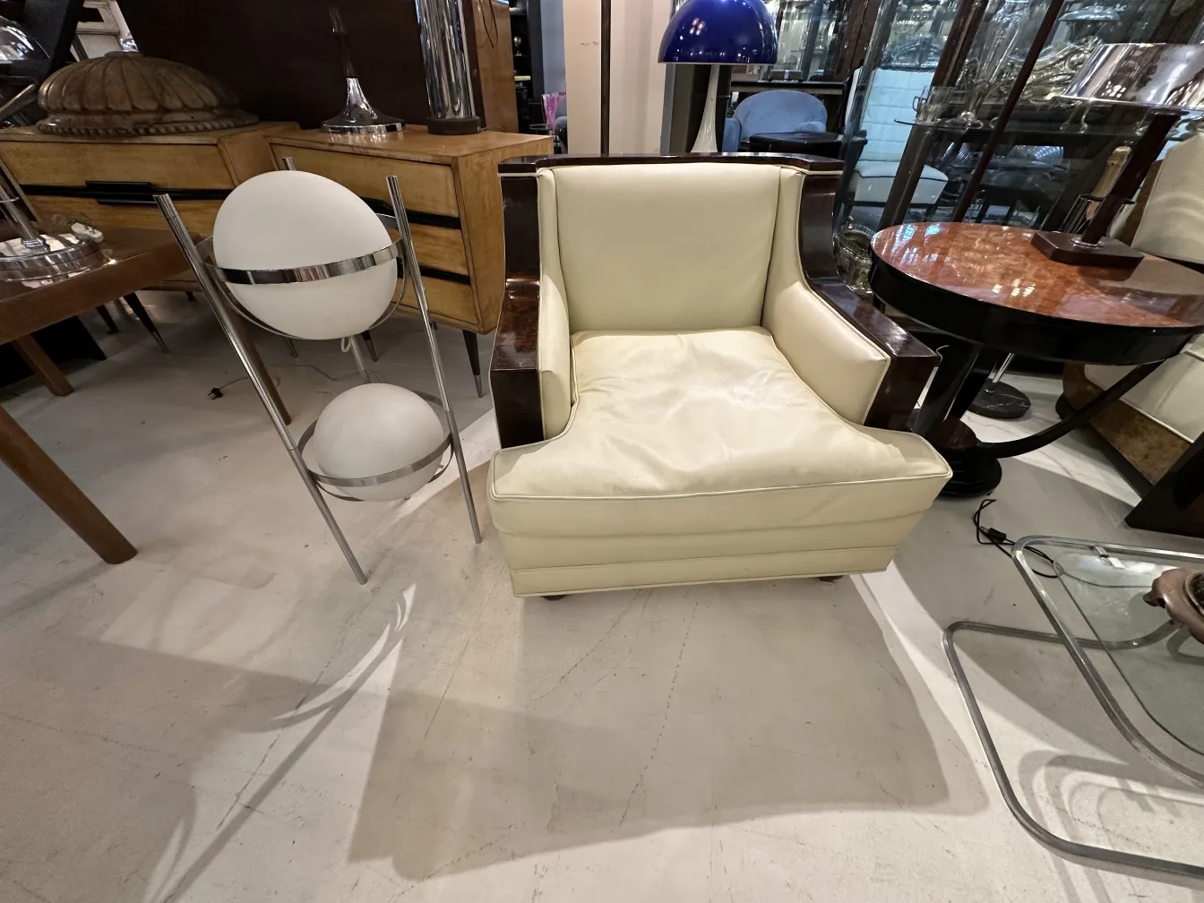 torchiere antique avec un design élégant à côté d'un fauteuil