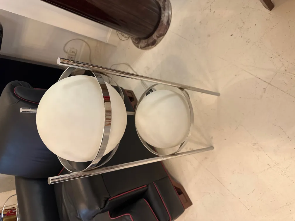 Antique floor lamp with a metal base and two white spheres, in a modern setting.