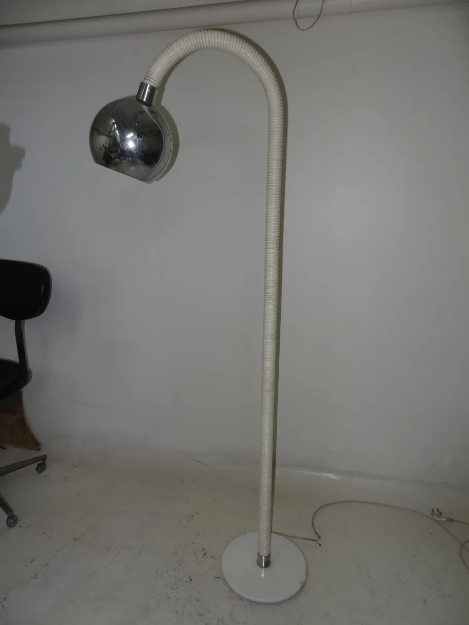 Lámpara de pie antigua con diseño curvo y base redonda en un ambiente neutral