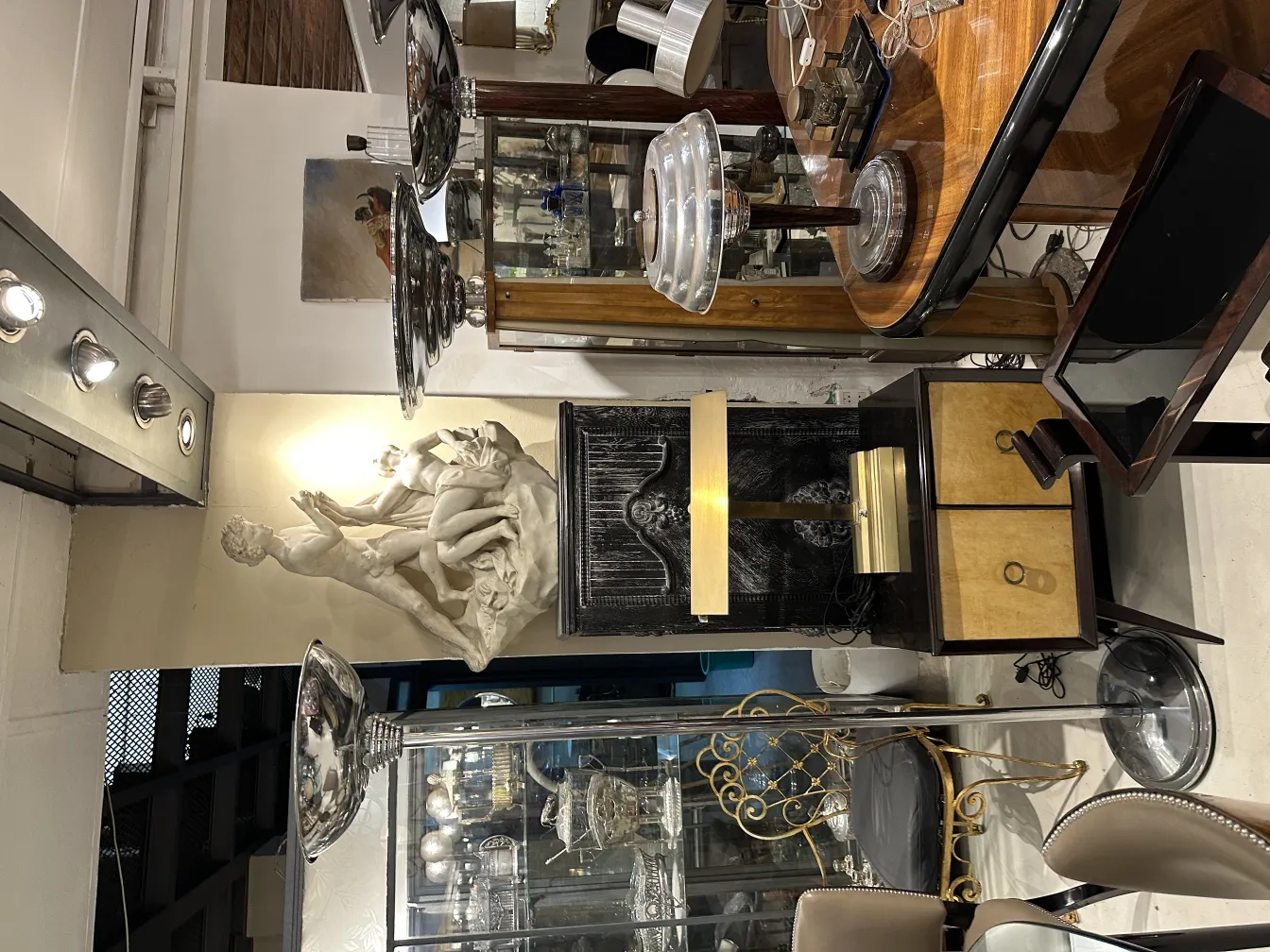 Two antique floor lamps in a decorative setting with a sculpture.