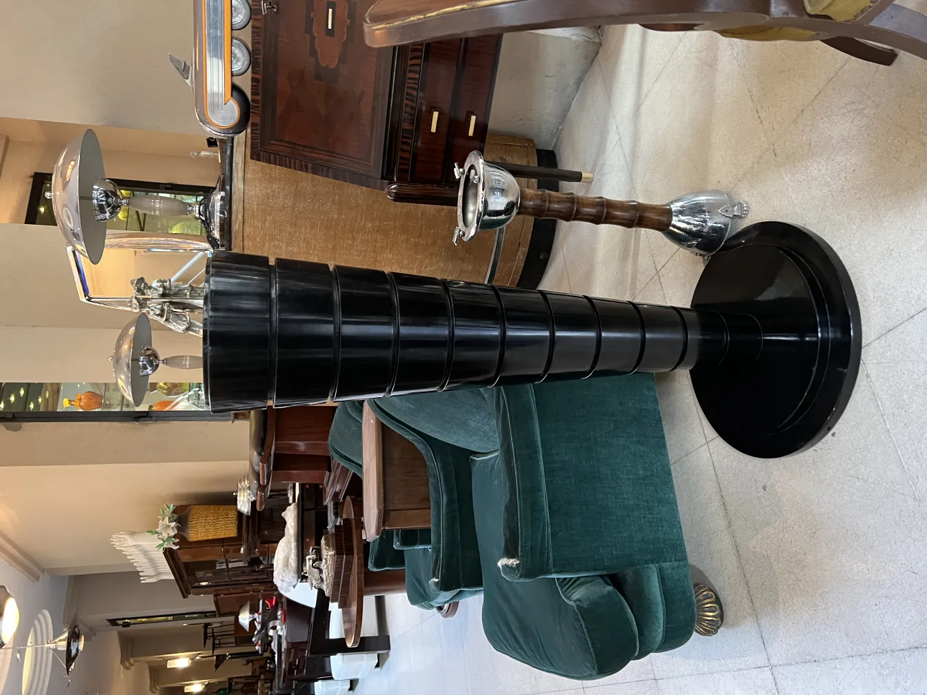 两个古董落地灯，环境优雅，有绿色扶手椅和复古装饰