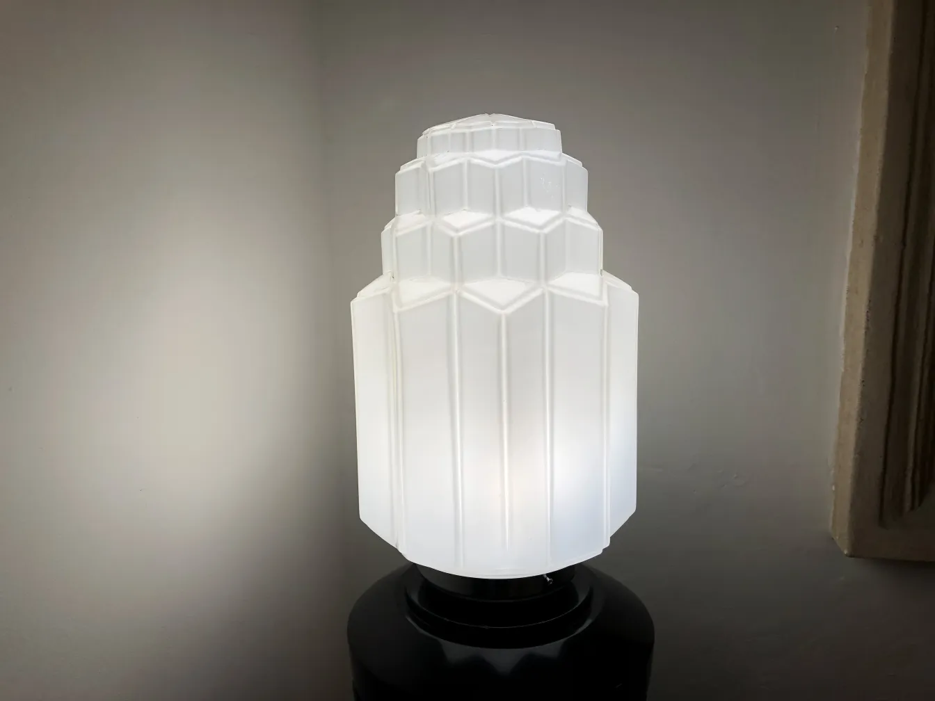 Lâmpada de piso antiga com cúpula branca e design único, em um ambiente aconchegante.