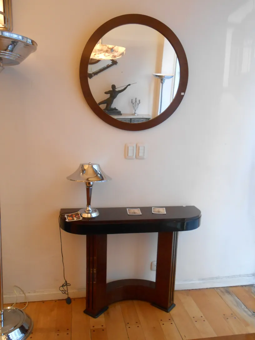 due lampade da terra antiche, una con paralume in metallo lucido, in una stanza elegante con specchio rotondo e console decorativa.