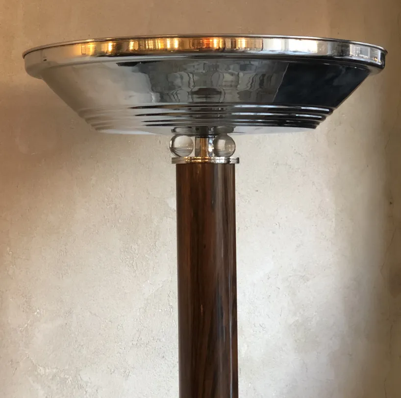Antique floor lamp with an elegant base and shiny shade in a cozy setting.