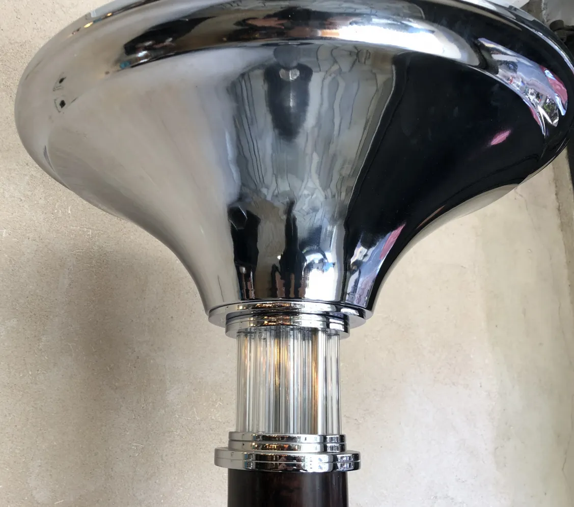 Two antique floor lamps with a shiny finish and elegant design, in a modern setting.