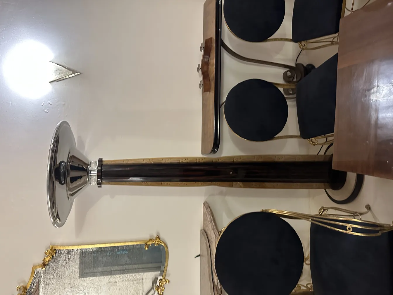 Duas lâmpadas de piso antigas em um ambiente elegante, com cadeiras e mesa decoradas.