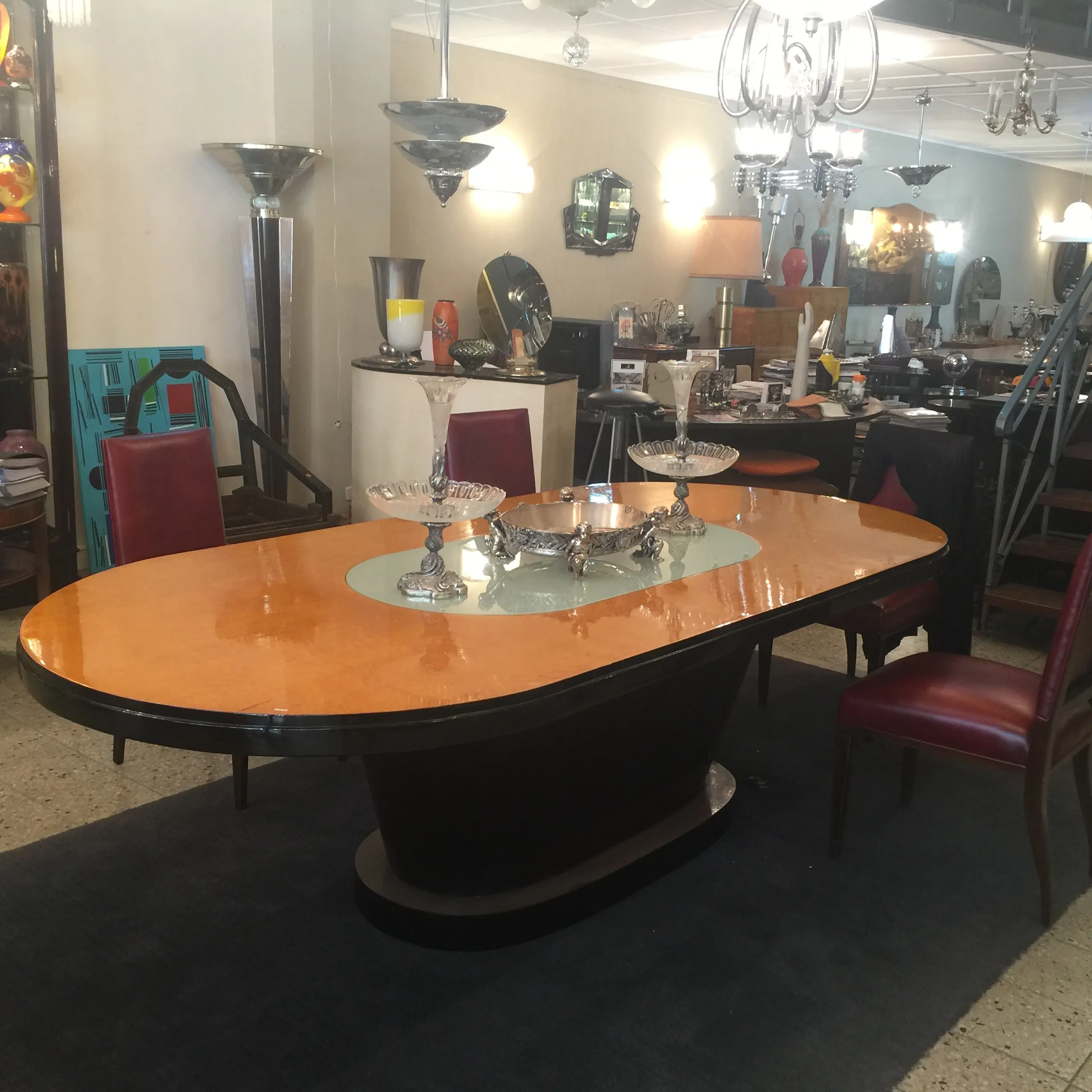 Tavolo da pranzo antico in stile Art Deco per 10 persone, circondato da eleganti sedie e decorazioni.