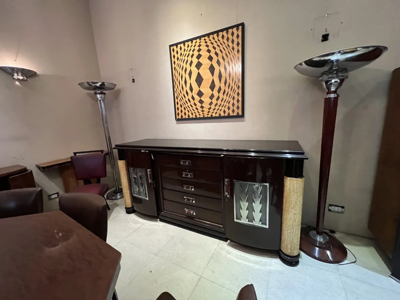 Duas lampadas de piso antigas ao lado de um elegante aparador.