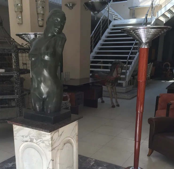 two antique floor lamps in a decorative setting with a statue