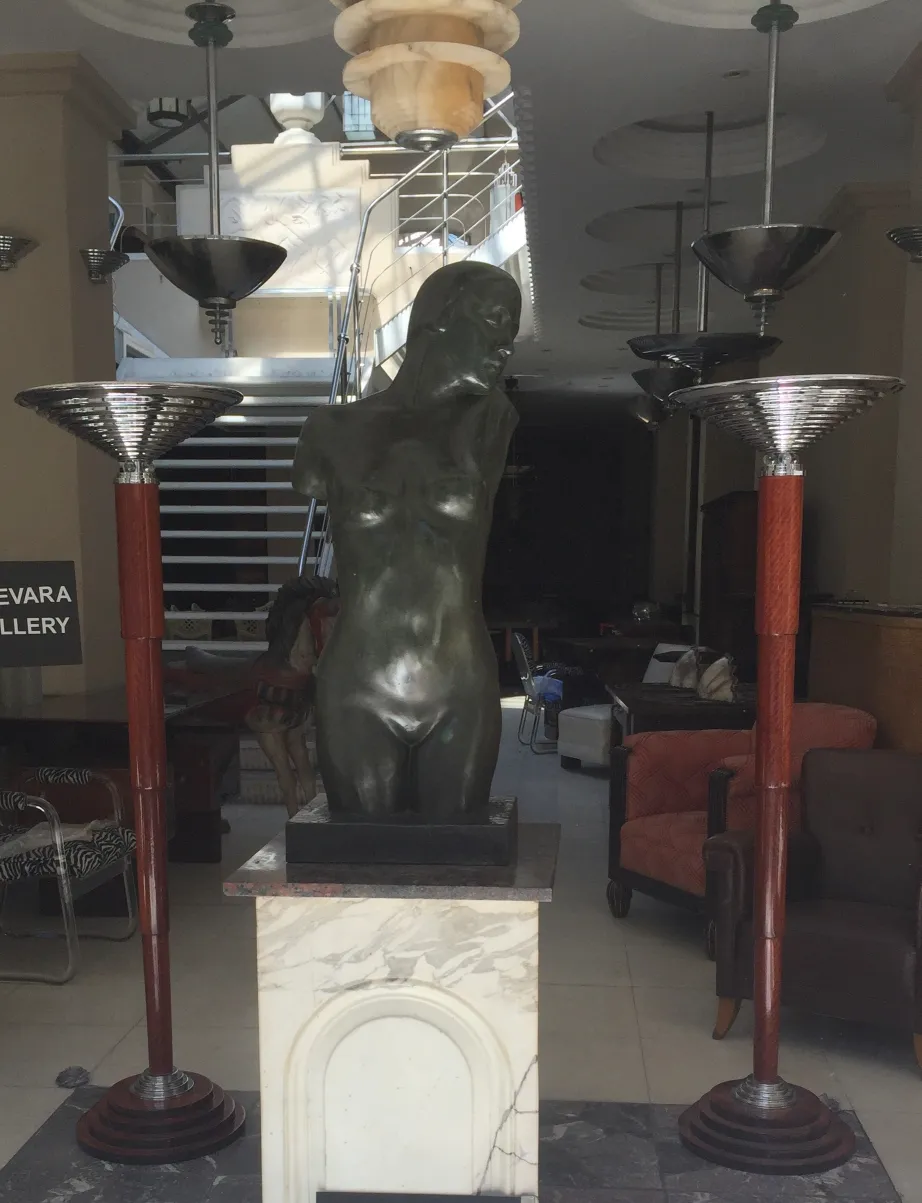 Deux lampadaires anciens avec des détails élégants à côté d'une sculpture