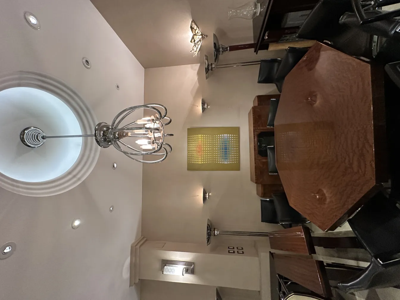 Vista de dos lámparas de pie antiguas en un ambiente elegante con mesa de madera y sillas.