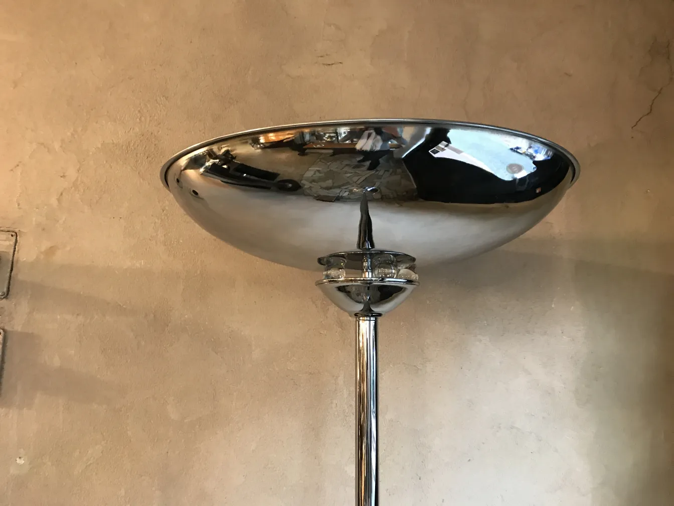 Vista superior de dos lámparas de pie antiguas con cúpula brillante en una pared texturada.