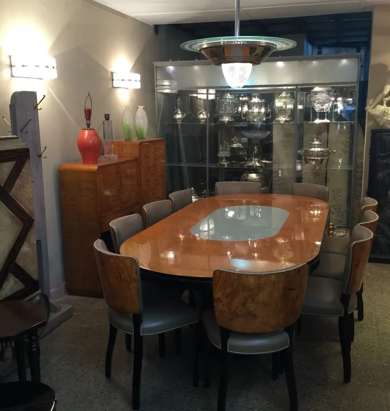 Table de repas ancienne pour 10 personnes avec chaises et lumière.