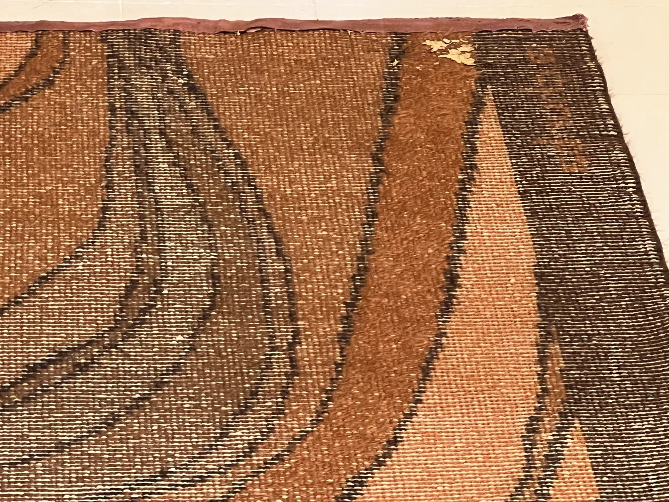 alfombra antigua con diseño en tonos marrones y texturas variadas