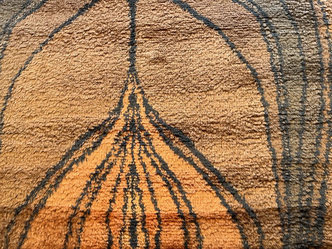 alfombra antigua con diseño en tonos marrones y negros