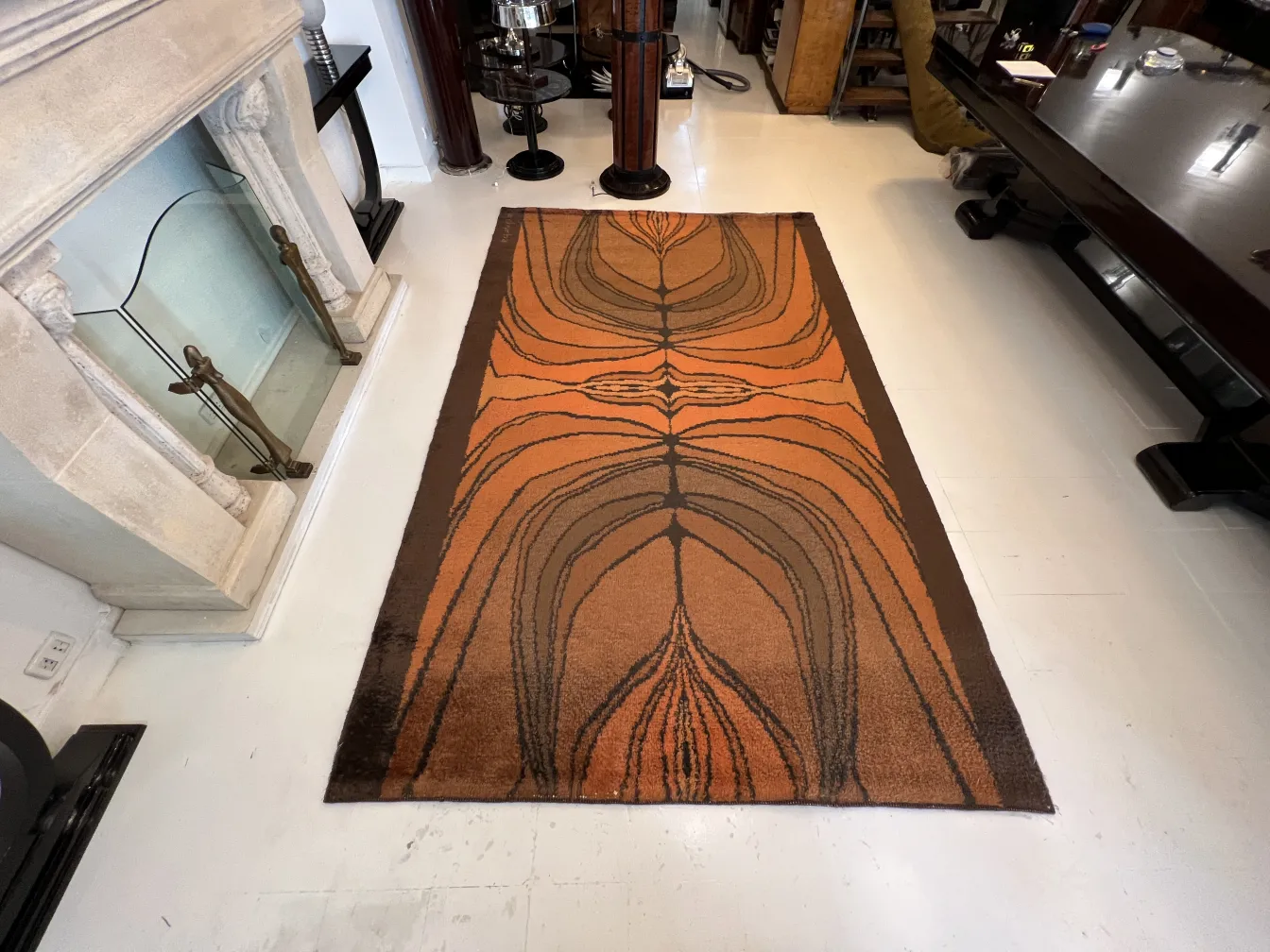 tapis ancien avec un design géométrique en tons chauds, dans un cadre élégant