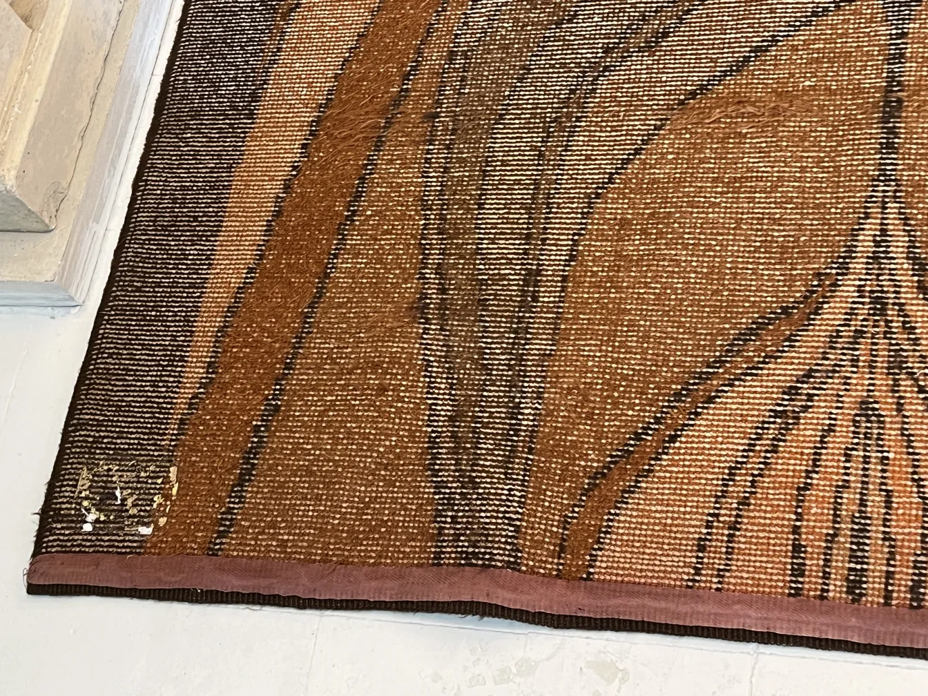 Tappeto antico con design elegante in tonalità marrone.