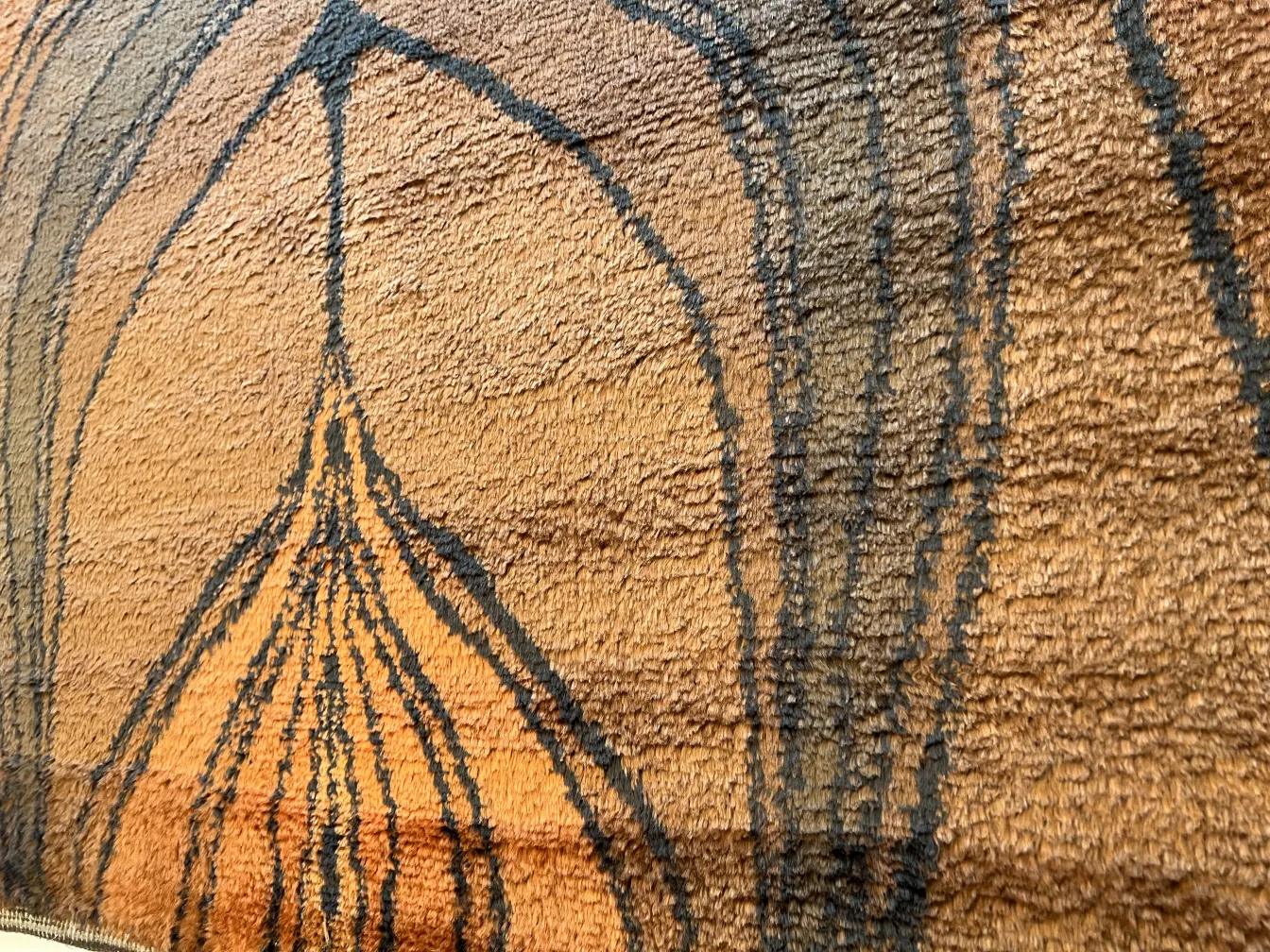 Antique carpet featuring warm tones and unique textures.