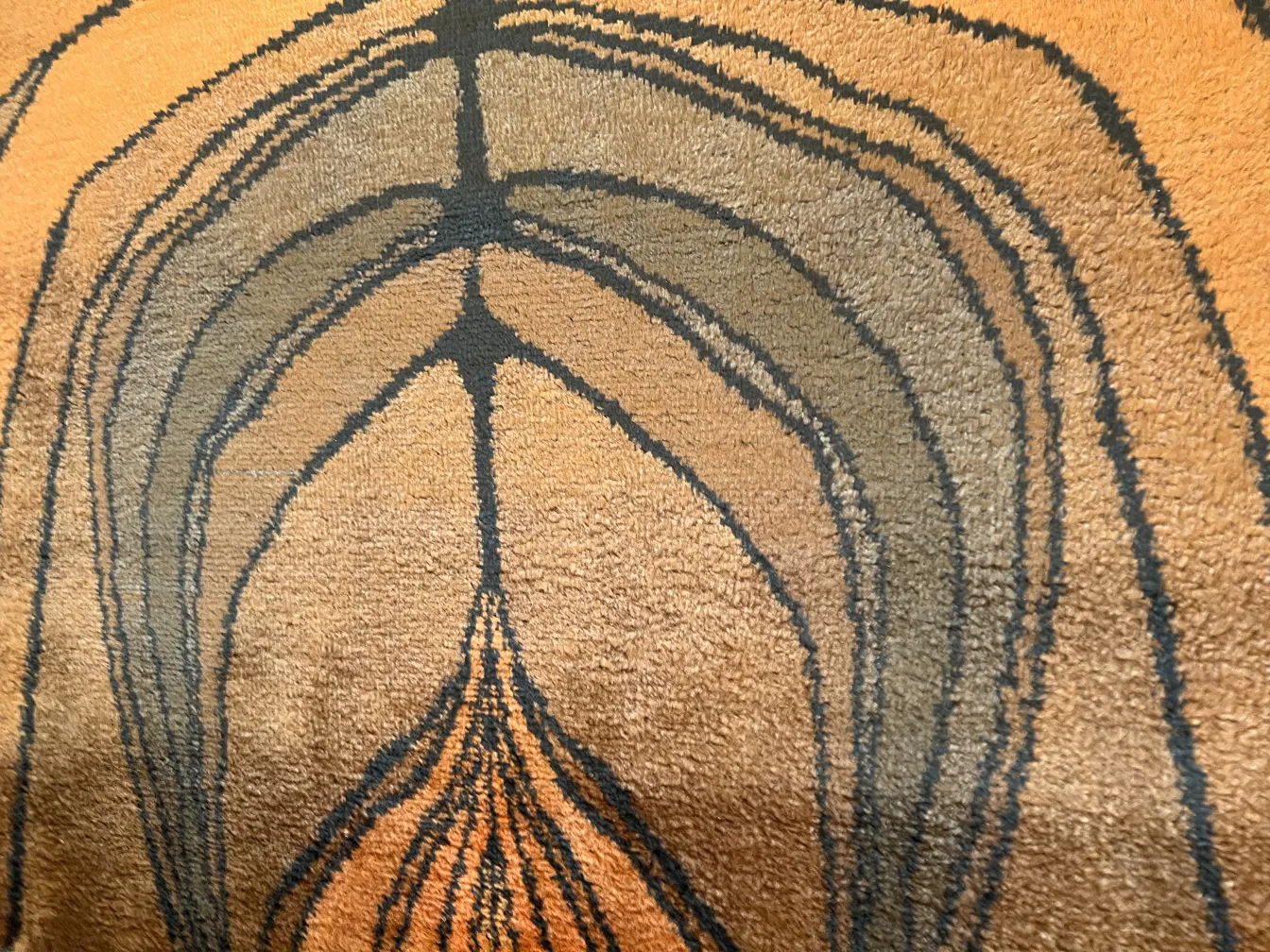 茶色と黒のトーンで描かれた抽象デザインの古いカーペット。