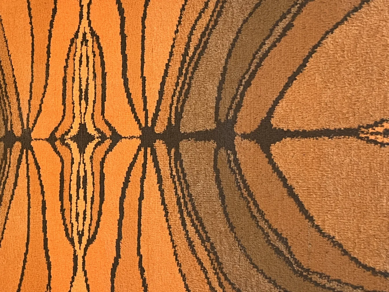 tapis ancien avec motif orange et noir, style géométrique