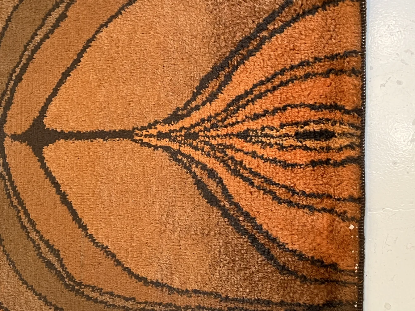 alfombra antigua con diseño en tonos marrones y negro