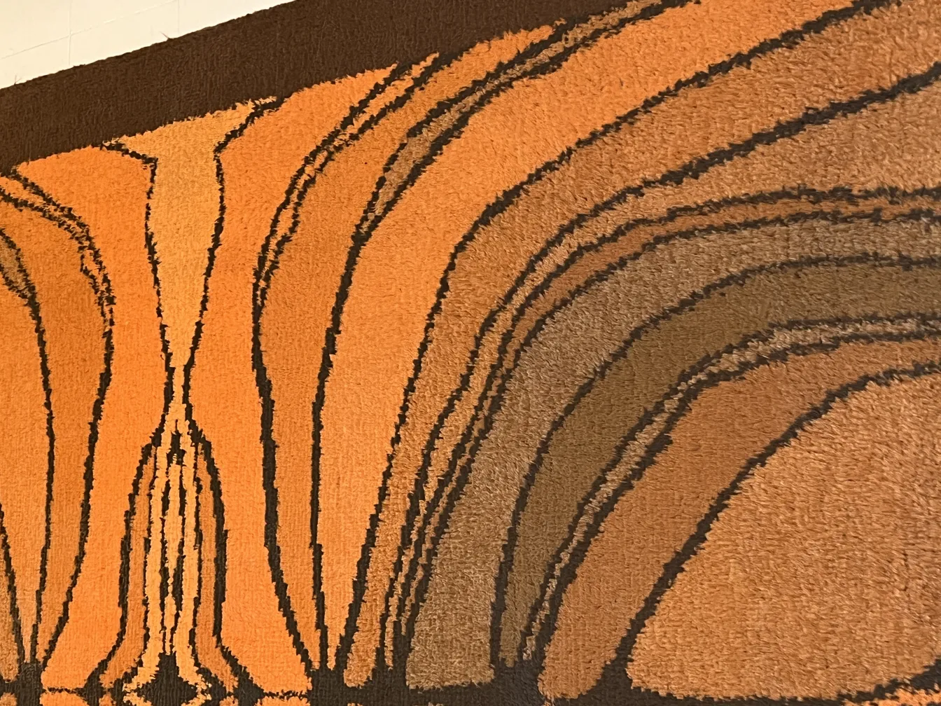 Alfombra antigua multicolor con diseño ondulado en tonos cálidos.