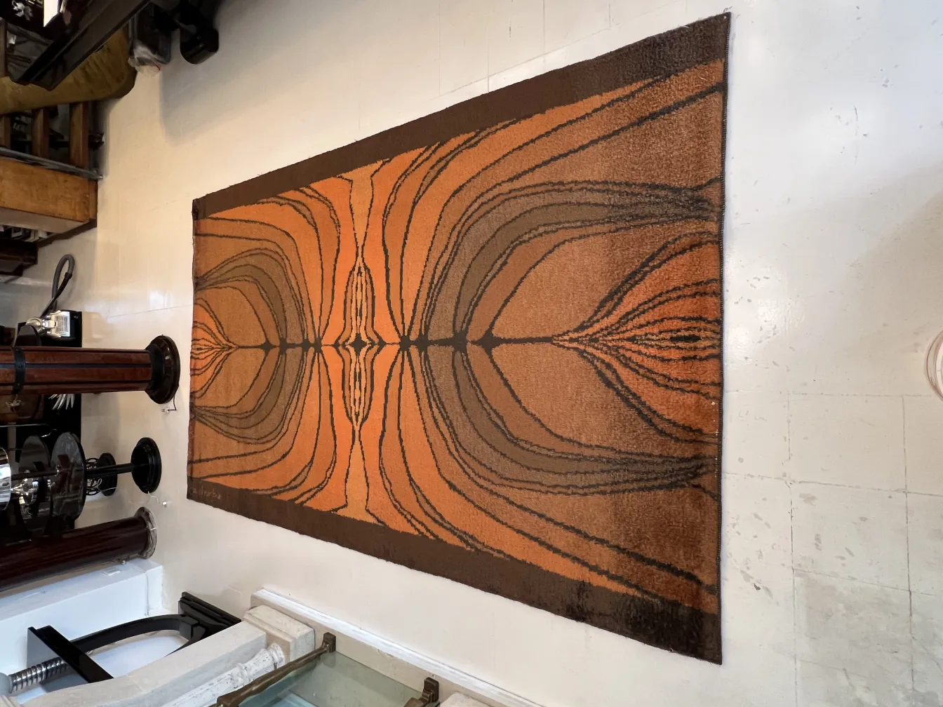 alfombra antigua con patrón en tonos terracota y marrón en un ambiente rústico