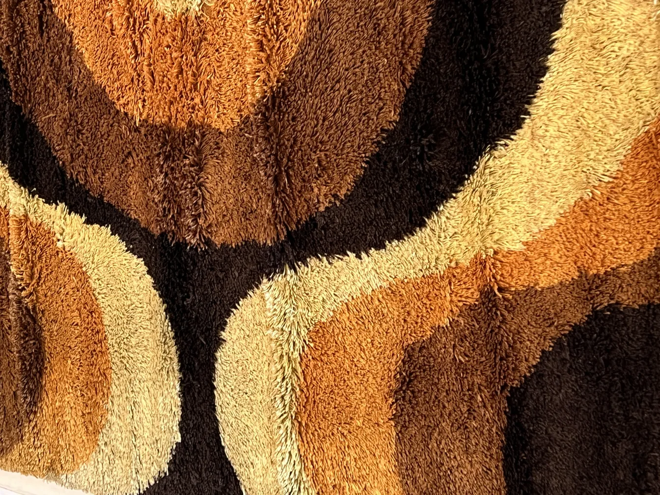 tapis ancien aux tons de marron et beige avec motifs ondulés