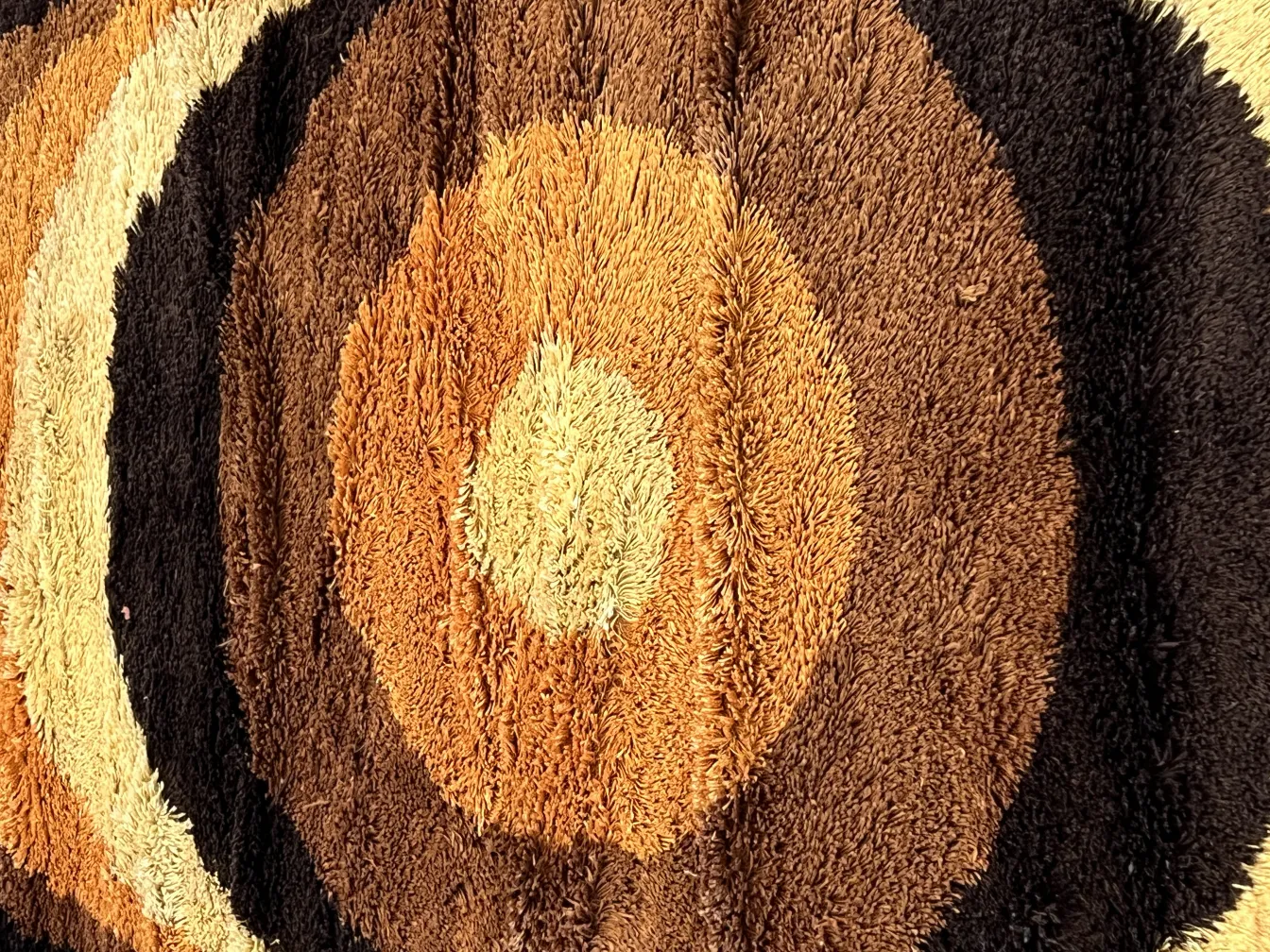 alfombra antigua circular de tonos marrones y beige