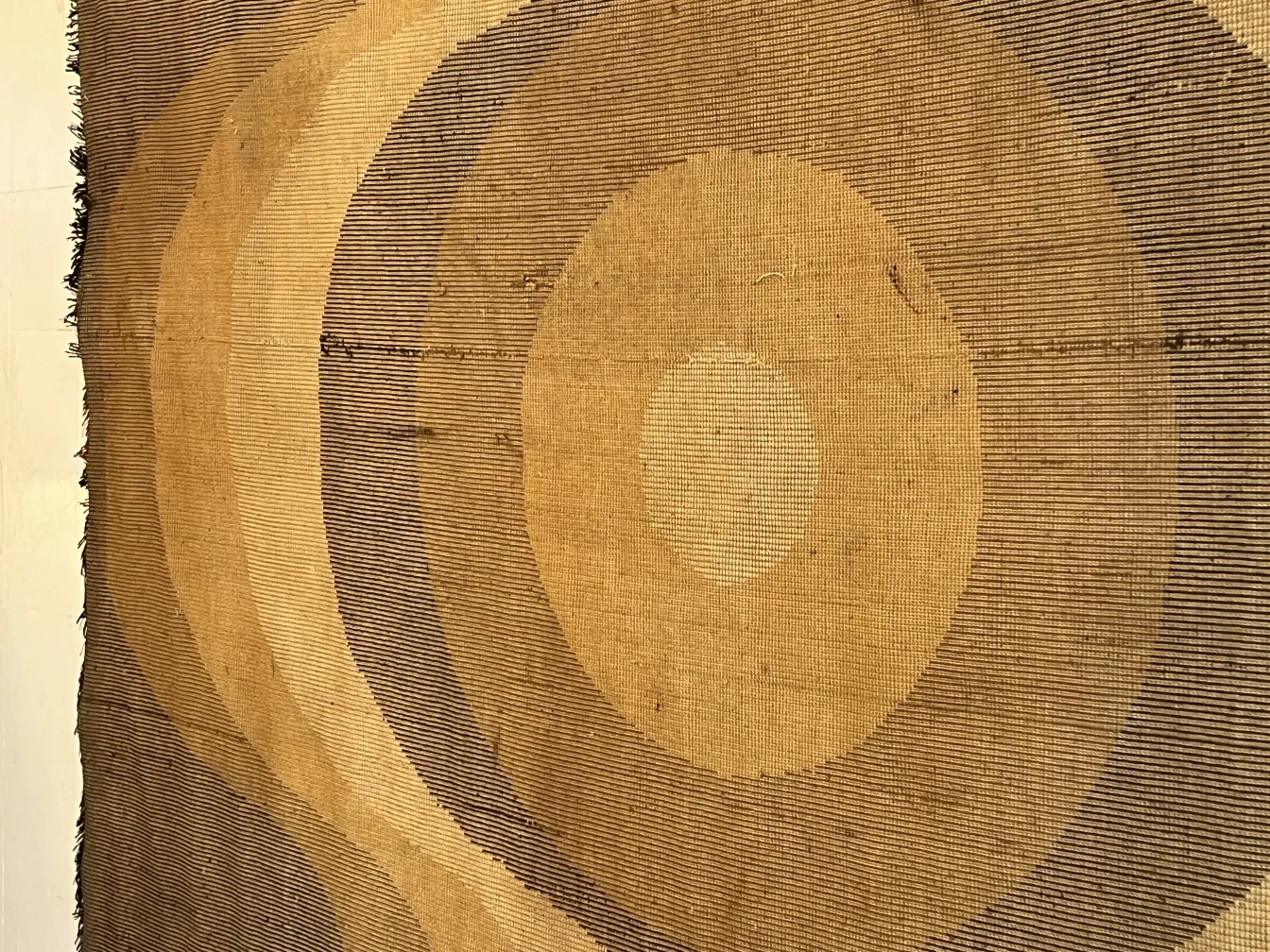 Alfombra antigua con diseño clásico de círculos marrones y beige.