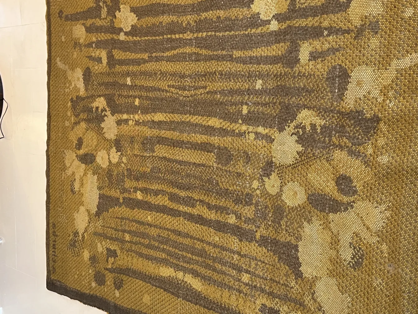 alfombra antigua con patrones en tonos marrones y amarillos