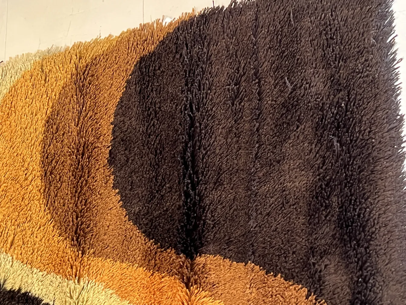 Tappeto antico con colori morbidi in toni di marrone e beige, ambiente caldo.