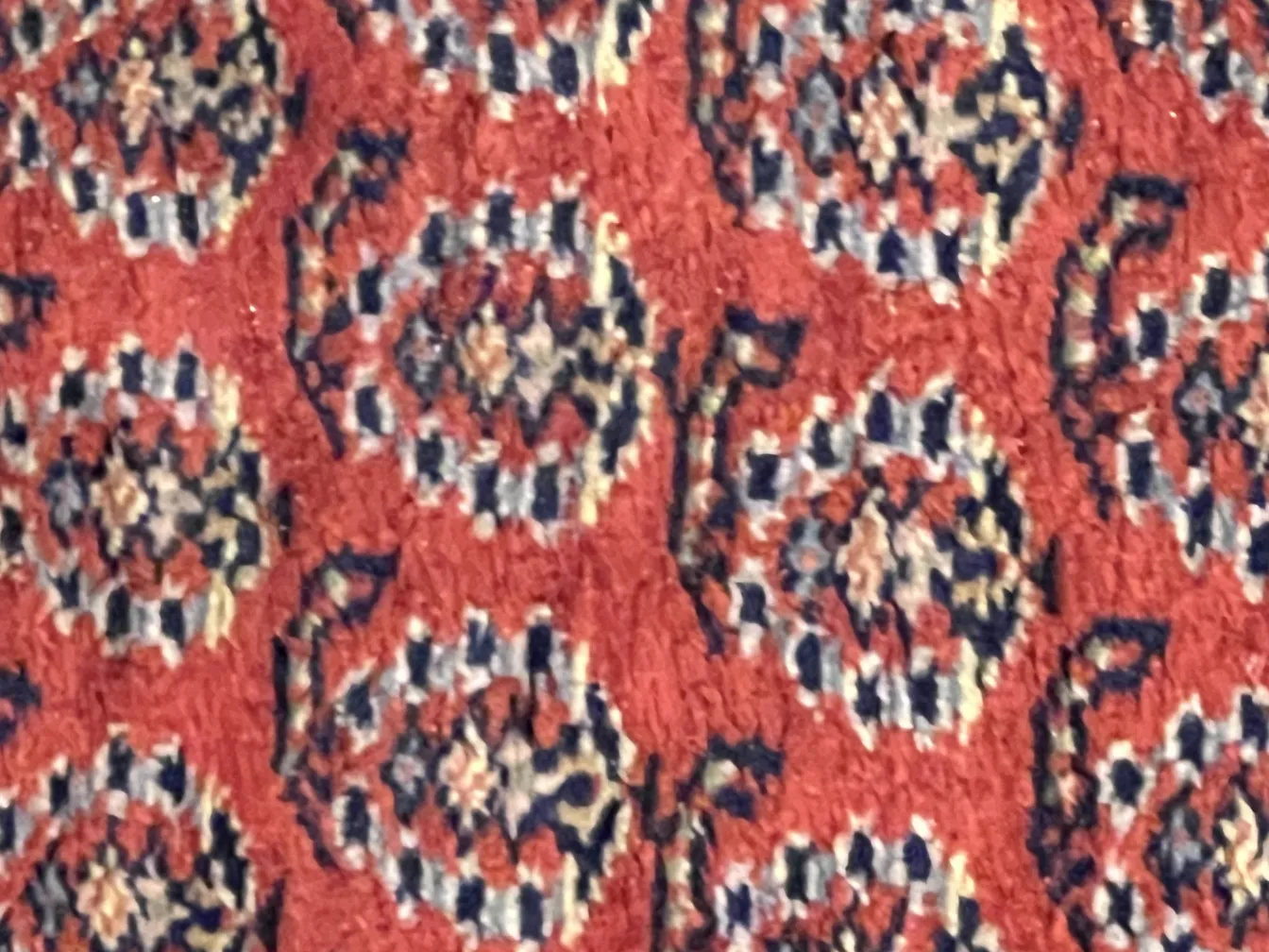 tapis ancien avec des motifs géométriques colorés