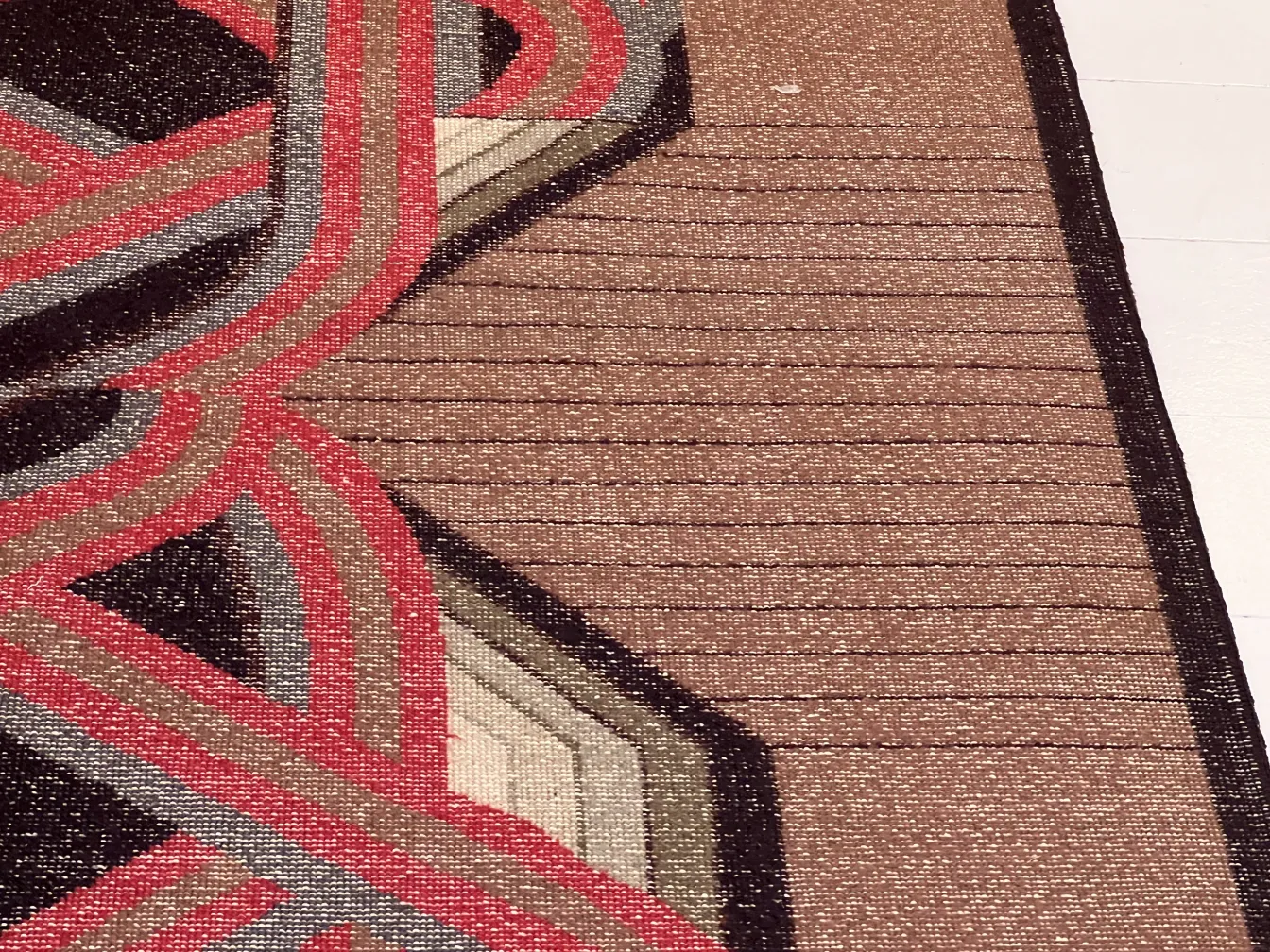 antique carpet with a geometric design in dark and light tones