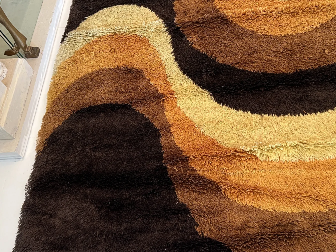 tappeto antico in tonalità marrone e oro con design ondulato